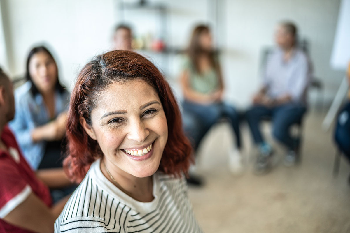 Portrait of mid adult woman during a group therapy at mental health center