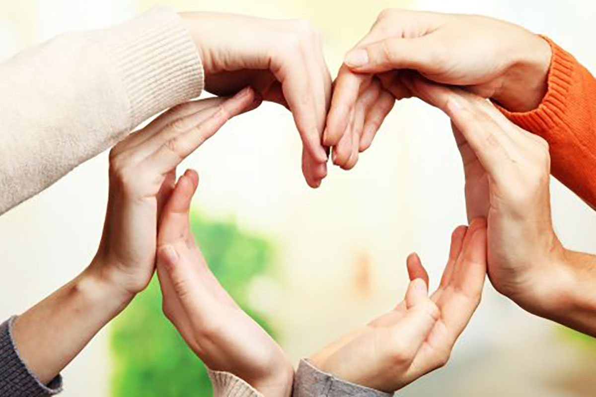 People making a heart shape with their hands