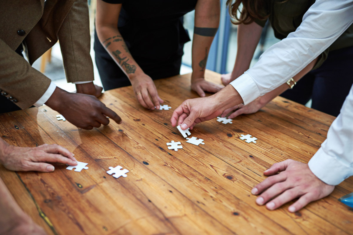 Cropped shot of a group of unidentifiable businesspeople building a puzzle together.